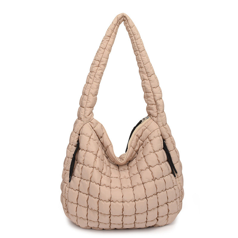 Beige quilted handbag on a white background freepeople coupon sale code skirt puffer bag dress white crop top girl cute clothing mindfully outfits cottagecore cotton good quality comfy chic vacation daily White quilted handbag on a white background