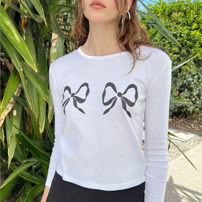 GORGEOUS SILVER BOW EARRINGS Displayed in a lifestyle setting with a model wearing bow print shirt.