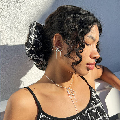 GORGEOUS GOLD BOW EARRINGS featuring a clean chic bow design and modern nature gold and black color ,perfect for dailylife/party/office/casual occasion. Displayed in a lifestyle setting with a black curly hair model wearing a  lot of bow accessories.