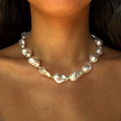 BAROQUE HOLOGRAPHIC PEARL WILMA PEARL NECKLACE featuring a clean chic design and modern white color ,perfect for dailylife/party/office occasion. Displayed in a elegant lifestyle setting with a model wearing camisole summer outfit.