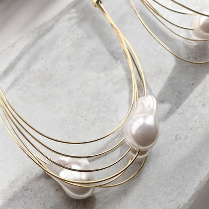 GORGEOUS GIANT BAROQUE PEARL GOLD HOOP EARRINGS featuring a clean chic design and modern white color ,perfect for dailylife/party/office/casual occasion. Styled against a white marble background.