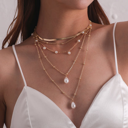 MULTI LAYER WATER DROP PEARL PENDANT WEDDING NECKLACE featuring a clean chic design and modern nature gold and pearl color ,perfect for dailylife/party/office/casual occasion. Displayed in a chic lifestyle setting with a model wearing a white top .