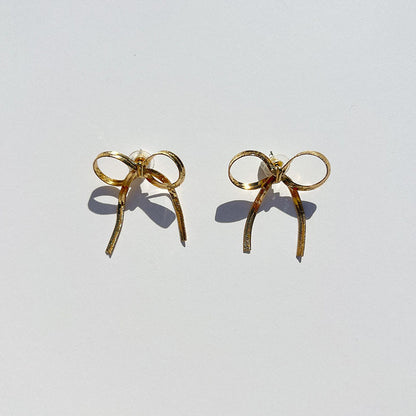 GORGEOUS GOLD BOW EARRINGS featuring a clean chic bow design and modern nature gold and black color ,perfect for dailylife/party/office/casual occasion. Styled against a white background.