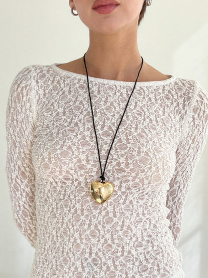 Puffy 3D Heart Necklace featuring a clean chic design and modern nature gold and black braided rope  ,perfect for dailylife/party/office/casual occasion. Displayed in a lifestyle setting with a model wearing a summer  lace outfit.