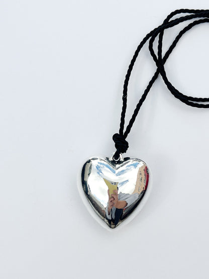 Puffy 3D Heart Necklace featuring a clean chic design and modern nature silver and black braided rope  ,perfect for dailylife/party/office/casual occasion. Styled against a white background.