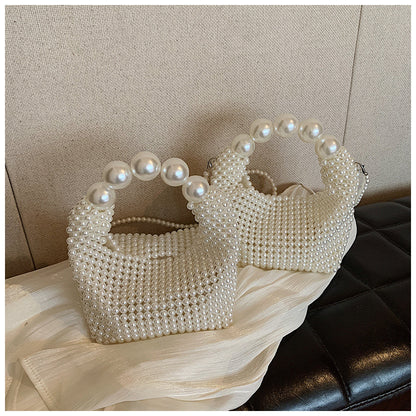 STATEMENTS OF HANDMADE PEARL BEADED HANDBAG WHITE featuring a clean chic pearl of big and small design  ,perfect for dailylife/party/office/casual occasion. Styled against a black sofa background.