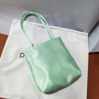 MILA LITTLE SILK BAG IN Pistachio Green Elegant silk tote handbag with a smooth finish, spacious interior, and sturdy handles, perfect for adding a touch of luxury to any outfit