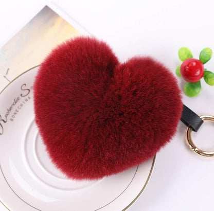 Genuine Rex Rabbit Hair Fur Pompom Keychain Heart Shaped Bag Charm Ring Fluffy Fur Ball featuring a clean chic design and fluffy red classic color ,perfect for daily /party/casual/office bagcharm/chain charm decoration . Styled against a white plate dinner table background.