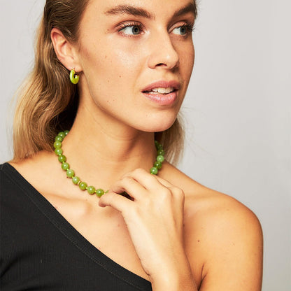 SOPHIA GREEN BOWL BEACH BALI NECKLACE featuring a clean chic design of Dyed green quartz & Glass beads in middle size and vintage green color with gold necklace clasp ,perfect for dailylife/party/office/casual occasion. Displayed in a romantic vacation vibe setting with a model wearing a black summer outfit.