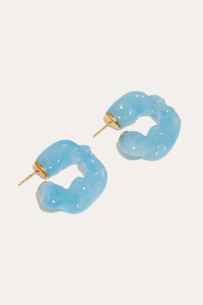 CULT STATEMENTPIECES BLUE BIO RESIN GOLD VERMEIL EARRINGS featuring a clean chic hoop design and modern jelly blue color ,perfect for dailylife/party/office/casual occasion. Styled against a white background.