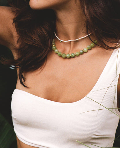 SOPHIA GREEN BOWL BEACH BALI NECKLACE featuring a clean chic design of Dyed green quartz & Glass beads in middle size and vintage green color with gold necklace clasp ,perfect for dailylife/party/office/casual occasion. Displayed in a romantic vacation vibe setting with a model wearing double layer necklaces.