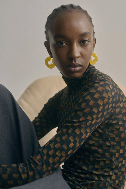 CULT STATEMENTPIECES BLUE BIO RESIN GOLD VERMEIL EARRINGS featuring a clean chic hoop design and modern jelly green color ,perfect for dailylife/party/office/casual occasion. Displayed in a cool  lifestyle setting with a black skin model wearing a black pants.