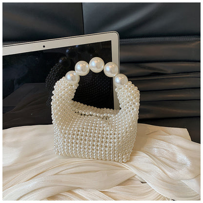 STATEMENTS OF HANDMADE PEARL BEADED HANDBAG WHITE featuring a clean chic pearl of big and small design  ,perfect for dailylife/party/office/casual occasion. Styled against a black sofa and ipad background.